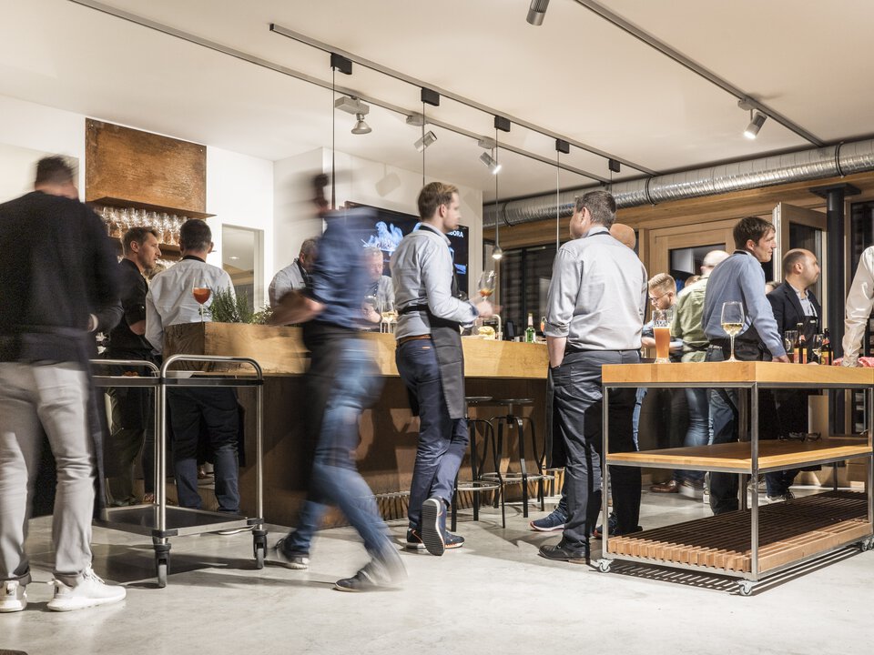 Menschen bei BORA Event in moderner Küche mit BORA Kochfeldabzug und hochwertigem Ambiente.