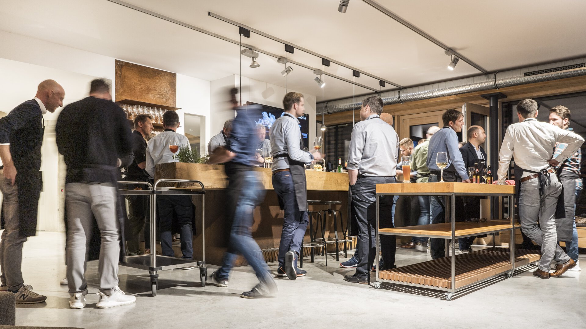 Menschen bei BORA Event in moderner Küche mit BORA Kochfeldabzug und hochwertigem Ambiente.