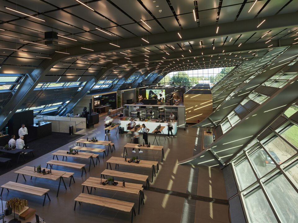 Moderne BORA Messehalle mit Kochstationen und großem Tageslichteinsatz in innovativer Architektur.