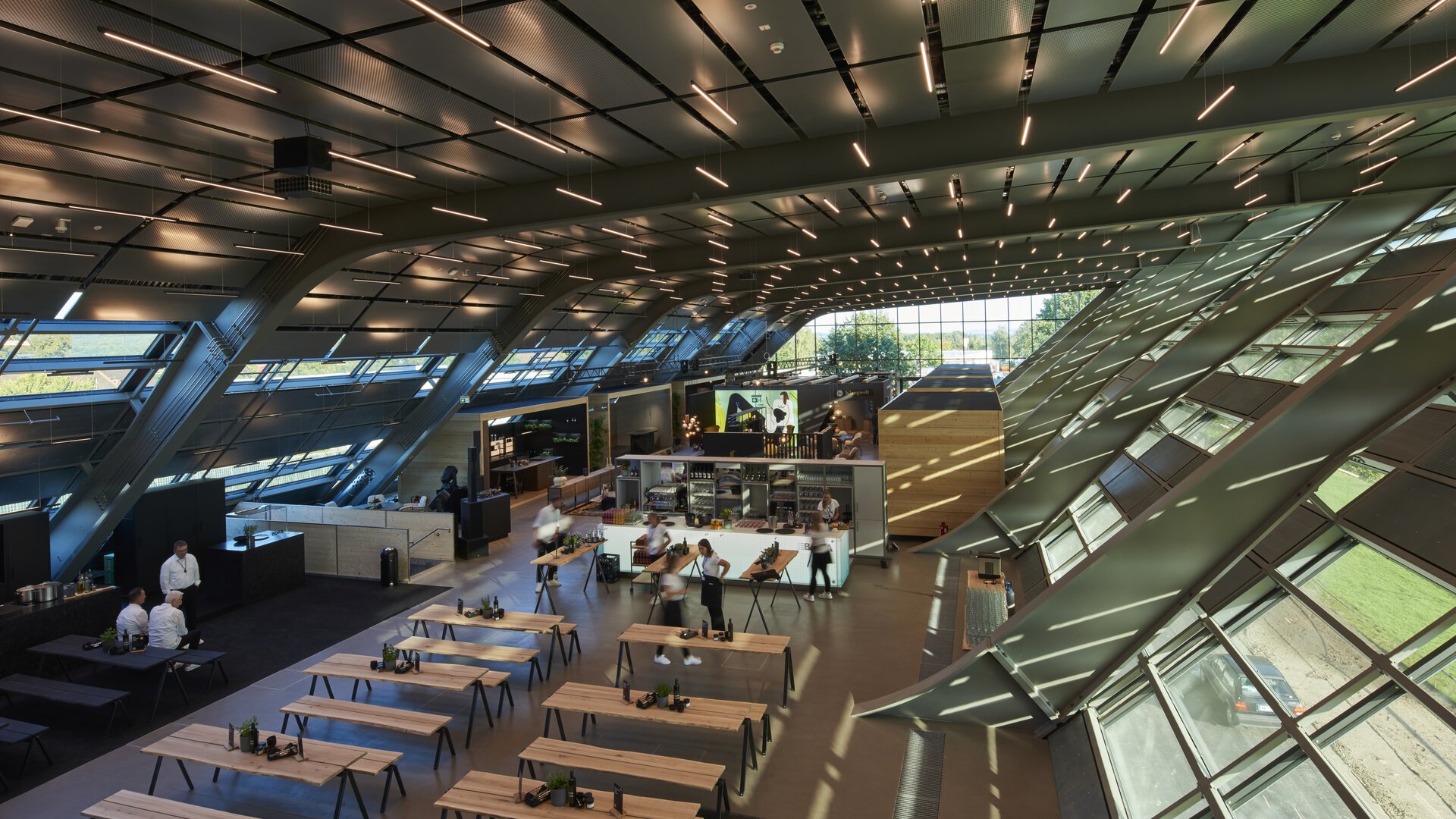Moderne BORA Messehalle mit Kochstationen und großem Tageslichteinsatz in innovativer Architektur.