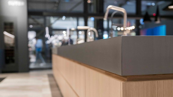 Moderne BORA Kücheninsel mit minimalistischer Holzfront und elegantem grauen Arbeitsplatten-Design in hochwertiger Ausführung.
