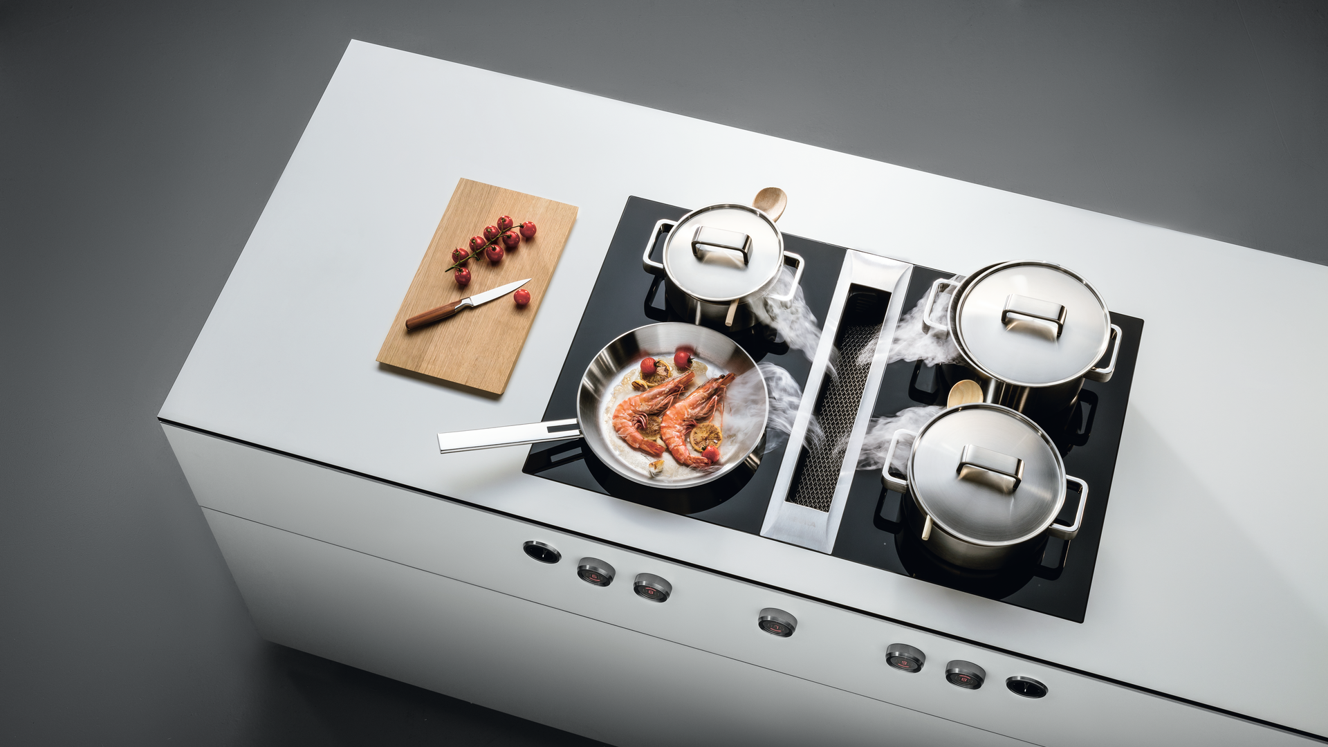 Moderne BORA Kochinsel mit Induktionsfeld und integriertem Kochfeldabzug, Pfanne mit Garnelen und Töpfen in edlem Design. Moderne BORA Kochinsel mit Induktionsfeld und integriertem Kochfeldabzug, Pfanne mit Garnelen und Töpfen in edlem Design.