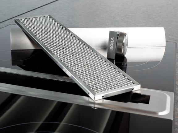 BORA Dunstabzug mit offenem Fettfilter auf Ceranfeld, modernes Kochfeld mit integriertem Abluftsystem. BORA Dunstabzug mit offenem Fettfilter auf Ceranfeld, modernes Kochfeld mit integriertem Abluftsystem.