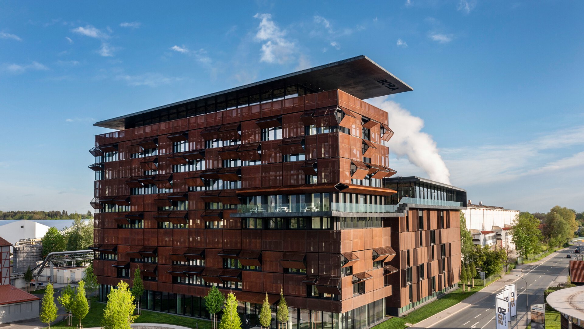BORA Firmenzentrale mit moderner Architektur und markantem Logo am Haupteingang unter blauem Himmel.