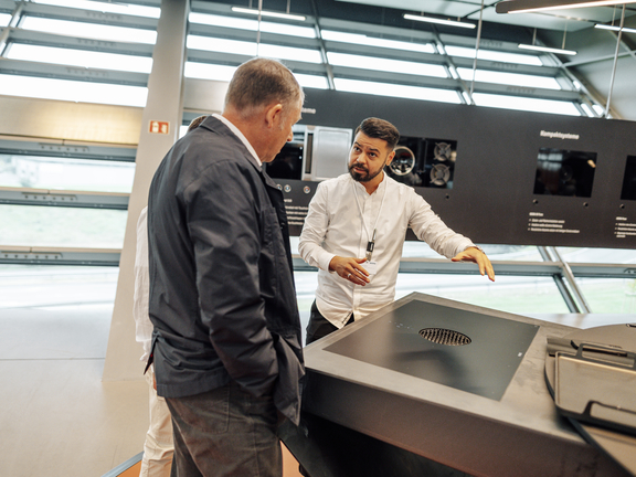 Zwei Personen besprechen BORA Kochfeld mit integriertem Abluftsystem in modernem Showroom.