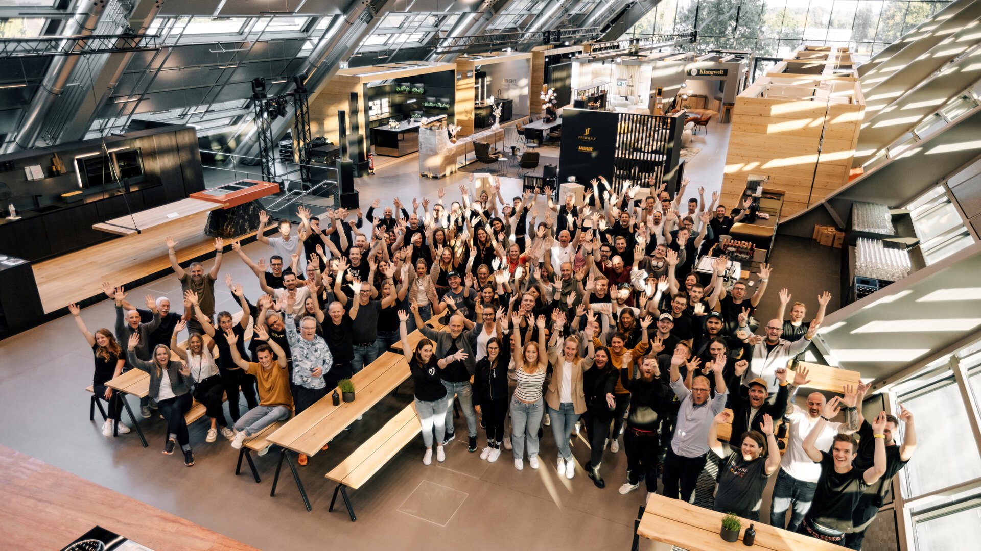 BORA Teamfoto im modernen Showroom mit BORA Kochfeldern und innovativen Küchengeräten im hellen, offenen Raum.