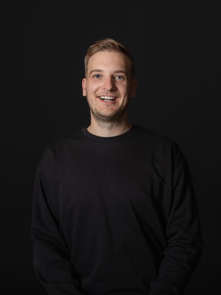 Schwarzer Pullover vor schwarzem Hintergrund, keine BORA-Produkte sichtbar.