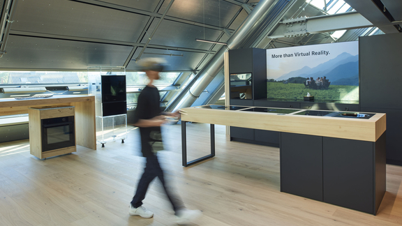 Moderne BORA Kücheninsel mit Kochfeld und Muldenlüfter in stilvollem Showroom mit Holz und schwarzen Fronten. Moderne BORA Kücheninsel mit Kochfeld und Muldenlüfter in stilvollem Showroom mit Holz und schwarzen Fronten.