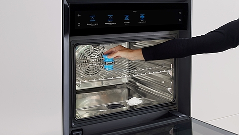 BORA_X_BO_cleaning_cartridge_with_hand_DE.jpg