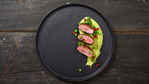 Ras el hanout spiced saddle of lamb with pea and mint houmous and pomegranate