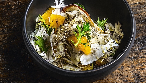 Blumenkohl-Orangen-Salat bestäubt mit Schwarztee, dazu Brotchips