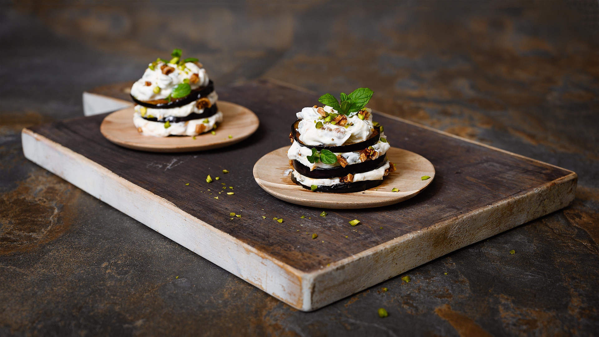 Millefeuilles d’aubergines et chèvre frais, agrémentés de pistaches, menthe et figues sèches