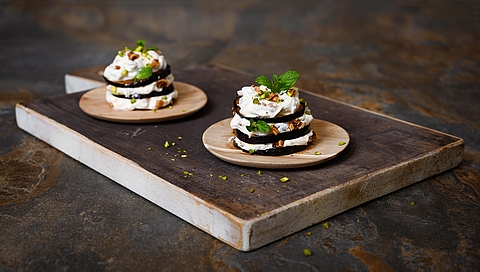 Aubergine towers with goat's cheese, pistachios, mint and dried figs