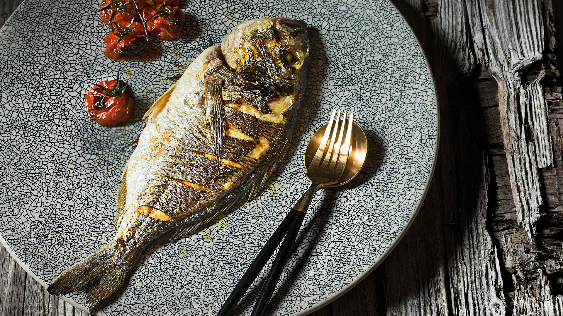 Roast gilthead bream on a bed of herb risotto with glazed cherry tomatoes