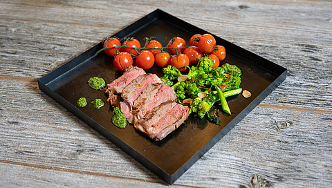 Entrecôte con broccoletti alle mandorle, pomodori stufati e salsa alle erbe