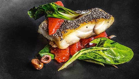 Hake in a chia seed crust with pink grapefruit, taggiasca olives and chard