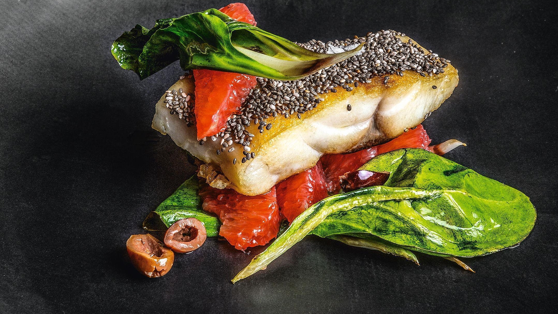 Hake in chia seed crust with pink grapefruit, taggiasca olives & chard