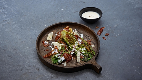 Grilled romaine lettuce with Parmesan dressing and crispy South Tyrolean bacon