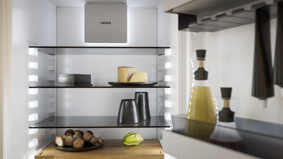 BORA Einbaukühlschrank mit geöffneter Tür, leere Regale und beleuchtetes Interieur. BORA Einbaukühlschrank mit geöffneter Tür, leere Regale und beleuchtetes Interieur.