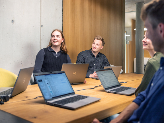 Teammeeting mit Laptops in modernem Büro, keine BORA Produkte sichtbar.
