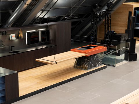 Moderne Küche mit freischwebendem BORA Kochfeld und integriertem Abluftsystem auf Natursteinbasis.