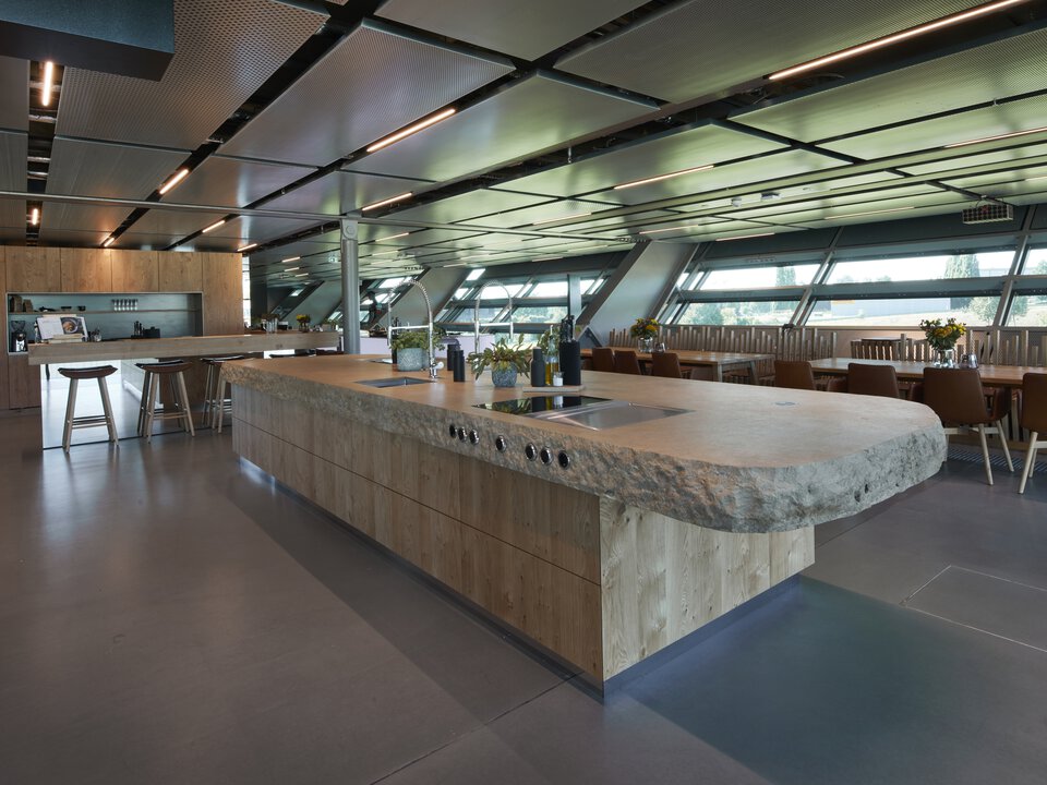 Modern BORA kitchen with central cooking island and integrated BORA cooktop extractor system in spacious dining area.