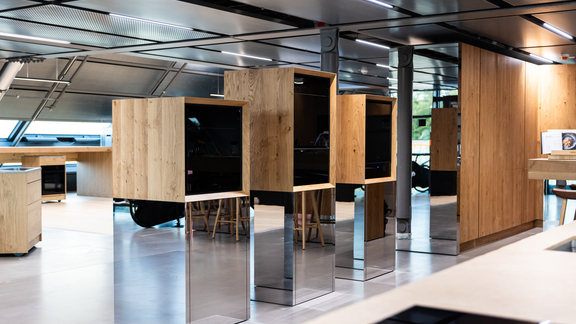 Modernes Küchenstudio mit BORA Geräteinseln und zeitlosem Holzdesign auf Edelstahl-Sockeln. Modernes Küchenstudio mit BORA Geräteinseln und zeitlosem Holzdesign auf Edelstahl-Sockeln.