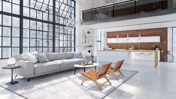 Moderner Wohnraum mit offener BORA Küche, hellem Sofa und großen Industrie-Fenstern in Loft-Design.