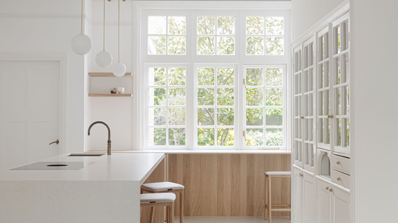Moderne helle Küche mit BORA Kochfeld und exklusiver Dunstabzugslösung, kombiniert mit Holz und Weiß.