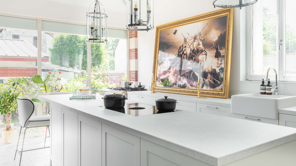 Moderne Küche mit BORA Induktionskochfeld und Dunstabzug, hellem Kochinsel-Design und großen Fenstern.