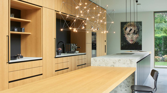 Moderne Kücheninsel mit integrierter BORA Kochfeldabzugtechnik und Holzfronten in hellem Design. Moderne Kücheninsel mit integrierter BORA Kochfeldabzugtechnik und Holzfronten in hellem Design.