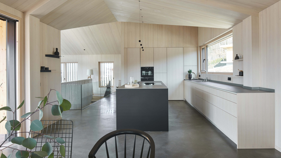 Moderne BORA Küche mit Kochinsel, minimalistischer weißer Front und integriertem Kochfeld in hellem Raumdesign. Moderne BORA Küche mit Kochinsel, minimalistischer weißer Front und integriertem Kochfeld in hellem Raumdesign.