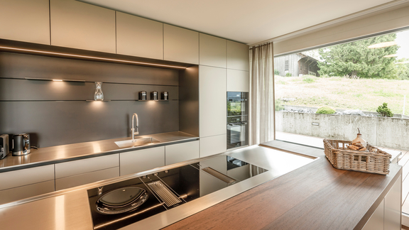 Moderne BORA Küche mit Induktionskochfeld und integriertem Lüftungssystem, helle Fronten und großer Fensterblick. Moderne BORA Küche mit Induktionskochfeld und integriertem Lüftungssystem, helle Fronten und großer Fensterblick.