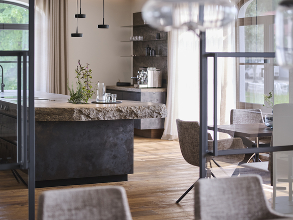 Moderne Wohnküche mit BORA Kochfeldabzug und natürlicher Steinarbeitsplatte in elegantem Design.