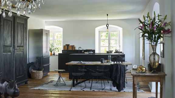 Moderne BORA Küche mit Kochfeld, Dunstabzug und Essbereich in hellem Landhausstil mit Holzboden.