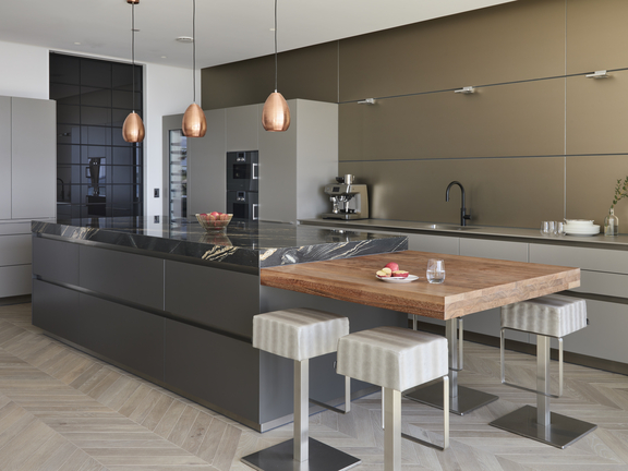 Moderne BORA Küche mit Kochinsel, integriertem BORA Kochfeld und geradlinigem Essbereich mit Barhockern und Holz-Tischplatte.