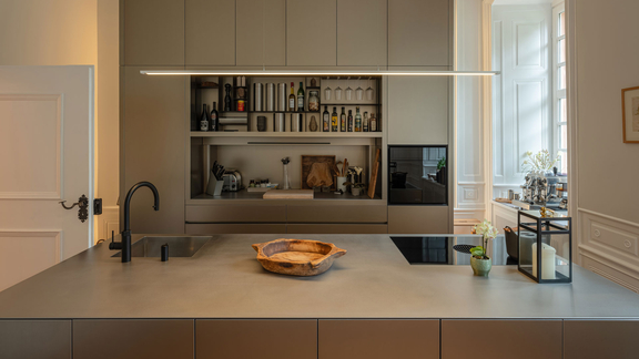 Moderne Küche mit BORA Kochfeld und Muldenlüfter, minimalistisches Design und stilvolle Kücheninsel aus Beton.