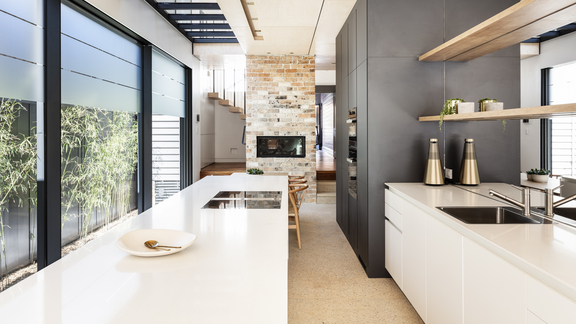 Moderne Küche mit BORA Kochfeld und Dunstabzug, minimalistisch gestaltet mit weißen Arbeitsflächen und schwarzer Küchenfront. Moderne Küche mit BORA Kochfeld und Dunstabzug, minimalistisch gestaltet mit weißen Arbeitsflächen und schwarzer Küchenfront.
