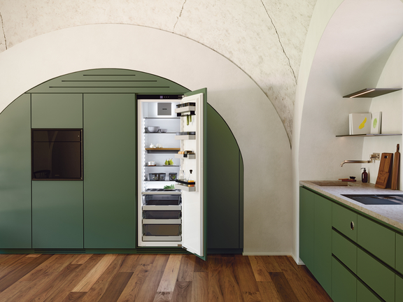 Moderne grüne BORA Küche mit integriertem offenem BORA Kühlschrank in elegantem Rundbogen-Design und Holzboden.